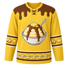 Load image into Gallery viewer, Ugly Thanksgiving Mashed Potato Mountain Hockey Jersey in Butter Yellow, front view – butter yellow body with gravy brown yoke with a round crest of a towering heap of mashed potatoes in a big bowl with a melting butter pat on top and a brown gravy river flowing down its slopes, a spoon planted in the peak, butter-and-gravy-drip yoke, potato and butter-pat sleeve bands and a mini potato-bowl hem band – custom name and number