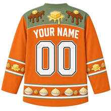 Load image into Gallery viewer, Ugly Thanksgiving Mashed Potato Mountain Hockey Jersey in Harvest Orange, back view with a butter-and-gravy-drip yoke, potato and butter-pat sleeve bands, mini mashed potato bowl hem band, arched YOUR NAME lettering and 00 – custom name and number
