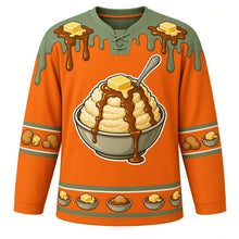 Load image into Gallery viewer, Ugly Thanksgiving Mashed Potato Mountain Hockey Jersey in Harvest Orange, front view – harvest orange body with sage green yoke with a round crest of a towering heap of mashed potatoes in a big bowl with a melting butter pat on top and a brown gravy river flowing down its slopes, a spoon planted in the peak, butter-and-gravy-drip yoke, potato and butter-pat sleeve bands and a mini potato-bowl hem band – custom name and number