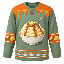 Load image into Gallery viewer, Ugly Thanksgiving Mashed Potato Mountain Hockey Jersey in Sage Green, front view – sage green body with harvest orange yoke with a round crest of a towering heap of mashed potatoes in a big bowl with a melting butter pat on top and a brown gravy river flowing down its slopes, a spoon planted in the peak, butter-and-gravy-drip yoke, potato and butter-pat sleeve bands and a mini potato-bowl hem band – custom name and number