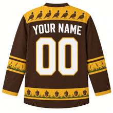 Load image into Gallery viewer, Ugly Thanksgiving Woodland Pheasant Brush Hockey Jersey in Woodland Brown, back view – brown body with a gold yoke showing a row of small pheasants, gold elbow bands with grass and a gold acorn and grass hem band with YOUR NAME and 00 – custom name and number