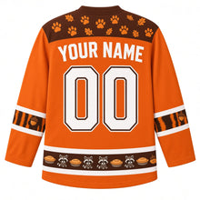 Load image into Gallery viewer, Ugly Thanksgiving Autumn Raccoon Raid Hockey Jersey in Pumpkin Orange, back view with a chestnut paw-print yoke, raccoon-tail-stripe sleeve bands, a hem band of pies and raccoons, YOUR NAME lettering and 00 – custom name and number