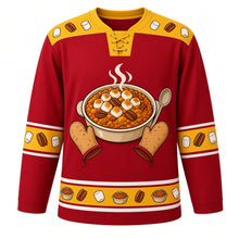 Load image into Gallery viewer, Ugly Thanksgiving Sweet Potato Casserole Hockey Jersey in Cranberry Red, front view – cranberry red body with golden yellow yoke with a round crest of a steaming sweet potato casserole topped with toasted marshmallows and pecans, framed by oven mitts and a serving spoon, marshmallow-and-pecan yoke, sweet potato sleeve bands and a mini casserole hem band – custom name and number