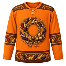 Load image into Gallery viewer, Ugly Thanksgiving Calico Corn Wreath Hockey Jersey in Pumpkin Orange, front view – pumpkin orange body with chestnut brown yoke with a round wreath of speckled red, purple and gold calico corn ears, wheat stalks and small gourds tied with a plaid bow, a wheat-sprig yoke and calico corn and gourd sleeve and hem bands – custom name and number