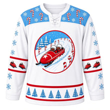 Load image into Gallery viewer, Ugly Christmas Bobsled Snow Run Hockey Jersey in Frost White, front view – round crest of a red two-person bobsled with a white star on its nose racing down a snowy track lined with candy canes and pine trees on a frost white body, ice blue candy-cane and snowflake yoke, blue snowflake sleeves with bobsled elbow bands and a pine tree hem band – custom name and number