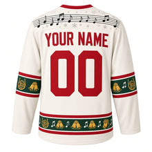 Load image into Gallery viewer, Ugly Christmas Brass Band Carols Hockey Jersey in Ivory White, back view with a music-staff yoke, french horn, jingle bell and note sleeve and hem bands, arched YOUR NAME lettering and 00 – custom name and number