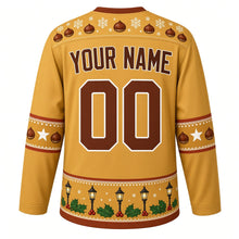 Load image into Gallery viewer, Ugly Christmas Roasted Chestnut Cart Hockey Jersey in Lamplight Gold, back view with a chestnut-and-snowflake yoke, chestnut sleeve bands, a street lamp and holly hem band, YOUR NAME lettering and 00 – custom name and number