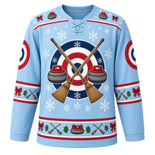 Load image into Gallery viewer, Ugly Christmas Curling Stone Cheer Hockey Jersey in Ice Blue, front view – ice blue body and crossed curling brooms over target rings flanked by two granite curling stones with a curling-stone and bow yoke, target-ring shoulder patches and bow and holly sleeve bands – custom name and number