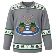 Load image into Gallery viewer, Ugly Christmas Curling Stone Cheer Hockey Jersey in Granite Gray, front view – crossed curling brooms over an ice-blue and navy curling house with two granite stones wearing green bows, broom-and-stone yoke and holly sleeve bands – custom name and number
