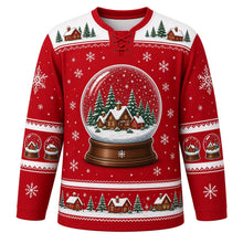 Load image into Gallery viewer, Ugly Christmas Snow Globe Village Hockey Jersey in Berry Red, front view – berry red body with white yoke with a giant snow globe crest with tiny glowing cottages, snowy pines and swirling snow, snow globe yoke, cottage and pine sleeve bands and a globe-and-house hem band – custom name and number