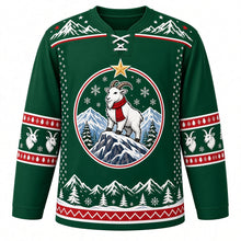 Load image into Gallery viewer, Ugly Christmas Mountain Goat Summit Hockey Jersey in Pine Green, front view – white mountain goat in a red knit scarf atop a rocky summit under a gold star, snowflakes and pines, snowy-peak yoke and red and white goat sleeve bands – custom name and number