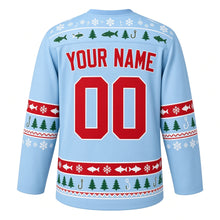 Load image into Gallery viewer, Ugly Christmas Ice Fishing Cabin Hockey Jersey in Frost Blue, back view with a fish-and-snowflake yoke, sleeve and hem bands of fish, hooks, pine trees and snowflakes, arched YOUR NAME lettering and 00 – custom name and number