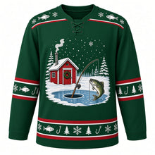Load image into Gallery viewer, Ugly Christmas Ice Fishing Cabin Hockey Jersey in Spruce Green, front view – spruce green body with a fish-and-snowflake yoke with a free-standing scene of a red ice-fishing shack with a wreath and smoking stovepipe on a frozen lake, a rod over an ice hole and a leaping fish among snowy pines, plus fish, hook, pine and snowflake bands – custom name and number