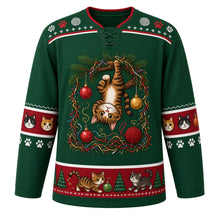 Load image into Gallery viewer, Ugly Christmas Kitty Ornament Chaos Hockey Jersey in Pine Green, front view – pine green body with a tabby cat dangling from a pine branch batting baubles above tangled tinsel and yarn balls, paw-print yoke, cat-face sleeve bands and a cats-and-pines hem band – custom name and number