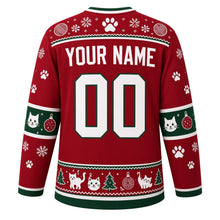 Load image into Gallery viewer, Ugly Christmas Kitty Ornament Chaos Hockey Jersey in Cranberry Red, back view with a paw-print, yarn-ball and snowflake yoke, cat-face and bauble sleeve bands, paw-print sleeves, a cats-trees-and-ornaments hem band, arched YOUR NAME lettering and 00 – custom name and number