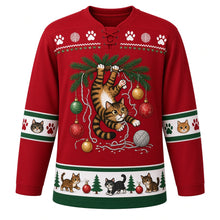 Load image into Gallery viewer, Ugly Christmas Kitty Ornament Chaos Hockey Jersey in Cranberry Red, front view – cranberry red body with a tabby cat dangling from a pine branch batting baubles above tangled tinsel and yarn balls, paw-print yoke, cat-face sleeve bands and a cats-and-pines hem band – custom name and number