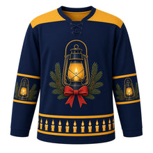 Load image into Gallery viewer, Ugly Christmas Candlelit Lanterns Hockey Jersey in Midnight Blue, front view – midnight blue body, glowing vintage lantern with a lit candle, pine boughs and a red bow on the chest, plain lantern gold yoke, small lantern sleeve bands and a hem row of lit candles – custom name and number