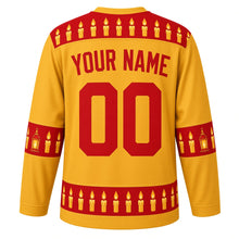 Load image into Gallery viewer, Ugly Christmas Candlelit Lanterns Hockey Jersey in Lantern Gold, back view with holly red yoke of lit candles, lantern and candle sleeve bands and a hem row of glowing candles, arched YOUR NAME and 00 – your name and number