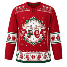 Load image into Gallery viewer, Ugly Christmas Mitten Clothesline Hockey Jersey in Cranberry Red, front view – four knit snowflake mittens pinned with wooden clothespins to a candy-striped line inside a holly wreath, mini mitten clothesline yoke, white mitten-pair sleeve bands and a white clothesline mitten hem band – custom name and number