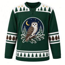 Load image into Gallery viewer, Ugly Christmas Snowy Owl Woods Hockey Jersey in Spruce Green, front view – spruce green body with white yoke with a round owl crest on a snowy pine branch under a crescent moon, pine-tree-and-star yoke, pinecone sleeve bands and a pine-tree hem band – custom name and number