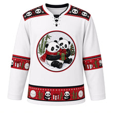 Load image into Gallery viewer, Ugly Christmas Panda Snow Romp Hockey Jersey in Frost White, front view – round crest of two cuddling pandas in the snow, one in a red knit scarf hugging a green gift box, with bamboo and a little Christmas tree, black panda-face yoke, red panda-and-gift sleeve bands and a bamboo and snowball hem band – custom name and number