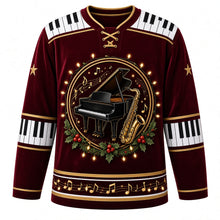 Load image into Gallery viewer, Ugly Christmas Piano Lounge Noel Hockey Jersey in Velvet Burgundy, front view – round crest of a black grand piano and a gold saxophone with gold music notes and holly, ringed by glowing string lights on a velvet burgundy body, piano-key yoke and elbow bands, gold sleeve stars and a music-note hem band – custom name and number