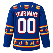 Load image into Gallery viewer, Ugly Christmas Rocking Horse Toybox Hockey Jersey in Royal Blue, back view with a toy drum and star yoke, a hem band of little rocking horses, drums and blocks, arched YOUR NAME lettering and 00 – custom name and number
