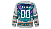 Load image into Gallery viewer, Ugly Christmas Winter Wonderland Hockey Jersey in Frost Gray, back view with arched YOUR NAME lettering, a big 00, a northern-lights sky, a pine forest and fox and snowflake hem band – custom name and number