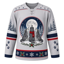 Load image into Gallery viewer, Ugly Christmas Moonlit Wolf Pack Hockey Jersey in Silver Frost, front view – silver frost body with a star-and-crescent-moon yoke with a round crest of three wolves, one in a red scarf, howling at a full moon above snowy pines, plus pine tree and paw print sleeves and a holly-and-snowflake hem band – custom name and number