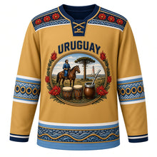 Load image into Gallery viewer, Uruguay Original Hockey Jersey in Pampa Gold, front view – ornate oval cameo crest with gaucho, ombú tree, candombe drums and ceibo flowers, detailed artwork, custom name and number