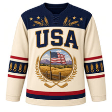 Load image into Gallery viewer, USA Patriotic Amber Waves Prairie Hockey Jersey in Wheat Cream, front view – golden wheat fields and purple mountains with a waving American flag, custom name and number
