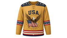 Load image into Gallery viewer, USA Patriotic Eagle and Flag Hockey Jersey in Prairie Gold, front view – spread-winged bald eagle gripping a rippling American flag, feather-pattern yoke, custom name and number, custom name and number