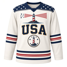 Load image into Gallery viewer, USA Patriotic Lighthouse Coast Beacon Hockey Jersey in Sea Foam White, front view – striped lighthouse on a rocky shoreline with a flag-stripe beam, custom name and number