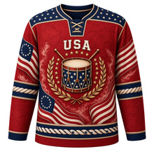 Load image into Gallery viewer, USA Patriotic Revolutionary Drum Corps Hockey Jersey in Musket Red, front view – antique colonial snare drum with crossed drumsticks and 13-star flag ribbons, custom name and number