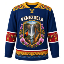 Load image into Gallery viewer, Venezuela Original Hockey Jersey in Caribbean Blue, front view – ornate tepui crest with Angel Falls, araguaney blossoms and a turpial, Wayuu-inspired woven yoke, detailed artwork, custom name and number