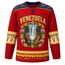 Load image into Gallery viewer, Venezuela Original Hockey Jersey in Llanos Red, front view – ornate tepui crest with Angel Falls, araguaney blossoms and a turpial, Wayuu-inspired woven yoke, detailed artwork, custom name and number