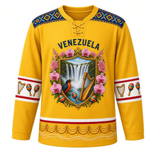 Load image into Gallery viewer, Venezuela Original Hockey Jersey in Araguaney Yellow, front view – ornate tepui crest with Angel Falls, araguaney blossoms and a turpial, Wayuu-inspired woven yoke, detailed artwork, custom name and number